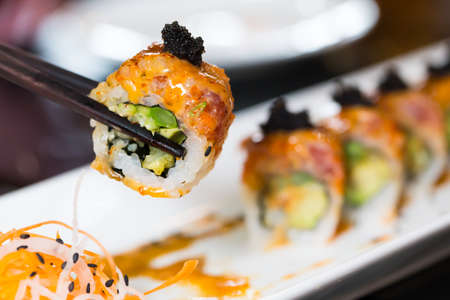 Sushi roll with black chopsticksの写真素材