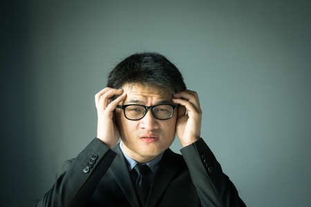 Businessman with stress and holding headの写真素材