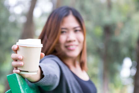 Asian woman holding coffee disposable cupの写真素材