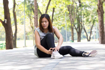 Sports injury. Woman with pain in ankle while joggingの写真素材