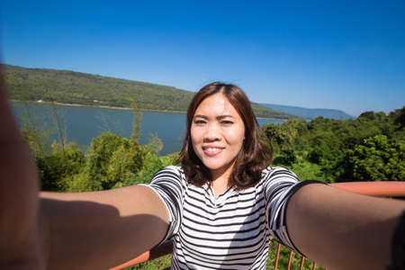 Asian young female tourist makes selfieの写真素材