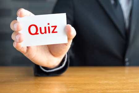 Quiz, message on white card and hold by 
businessmanの写真素材