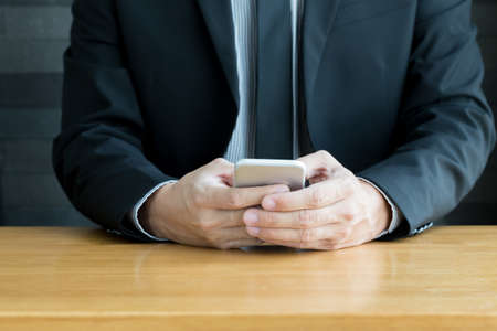 Businessman using mobile smart phone on deskの写真素材