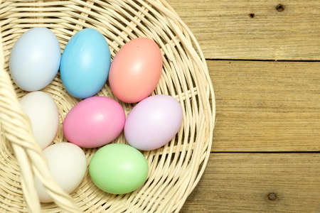 Easter eggs in the basket on wood backgroundの写真素材
