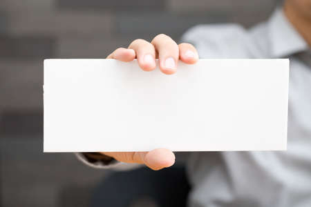 Hand of businessman showing white paperの写真素材