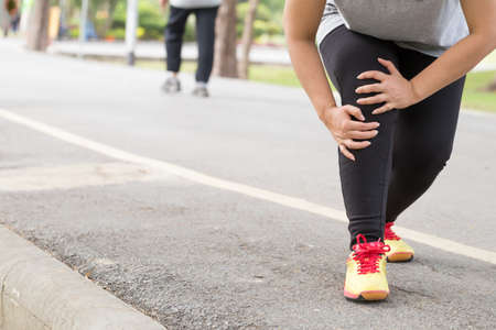 Sports injury. Woman with pain in knee while jogging