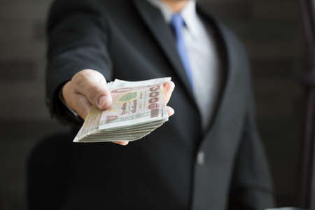 Businessman holding money thai bahtの写真素材
