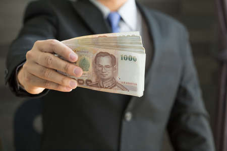 Businessman holding money thai bahtの写真素材
