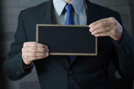 Hand of businessman showing black boardの写真素材
