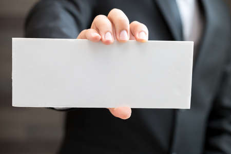 Hand of businessman showing white paperの写真素材