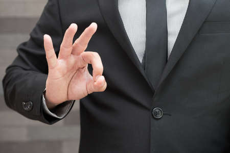 Businessman in suit and doing ok sign