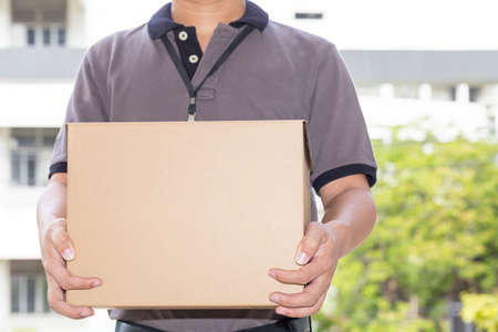 Delivery man holding a parcel box. Delivery service conceptの写真素材
