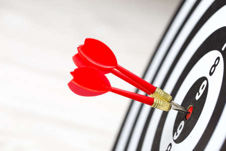 Target dart arrow hitting in the target center of dartboardの写真素材