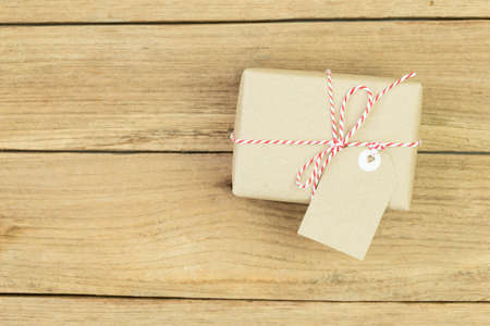 Gift box wrapped in recycled paper on wood backgroundの写真素材