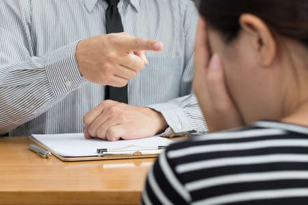 Businesswoman getting intimidated after scolded by bossの写真素材