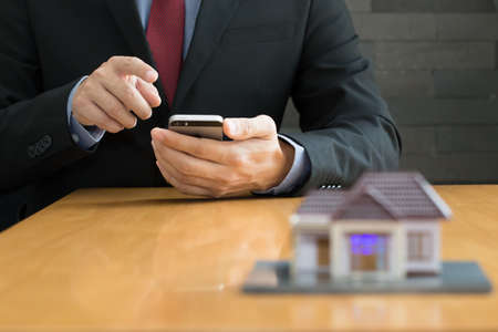 Businessman using mobile application for house property rentalの写真素材