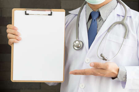 Medical doctor showing blank clipboardの写真素材