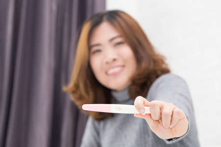 Happy asian woman holding pregnancy test, New life and new family conceptの写真素材