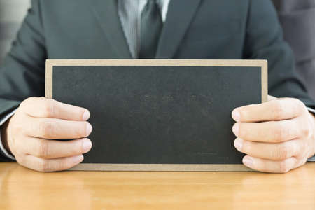 Hand of businessman showing black boardの写真素材