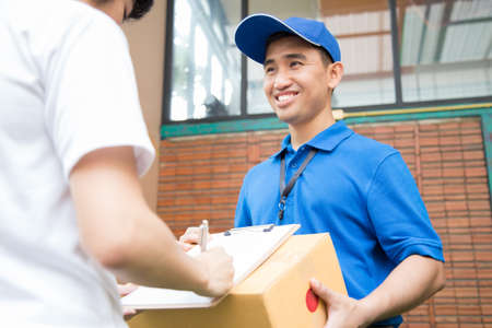 Woman hand accepting a delivery of boxes from deliveryman