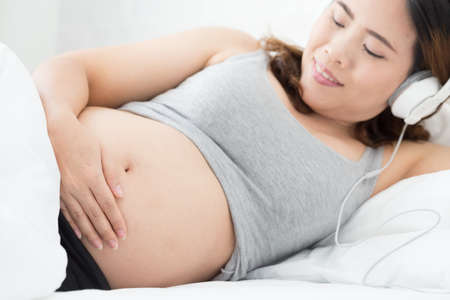Pregnant woman listening to musicの写真素材