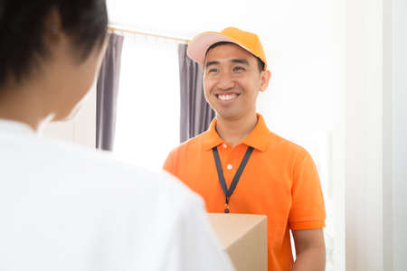 Woman accepting a delivery of cardboard boxes from deliverymanの写真素材