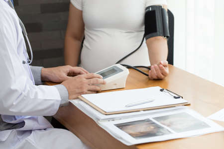 Doctor examining a pregnant woman and check blood pressureの写真素材