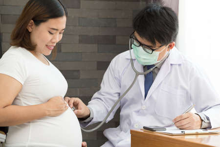 Doctor examining a pregnant womanの写真素材