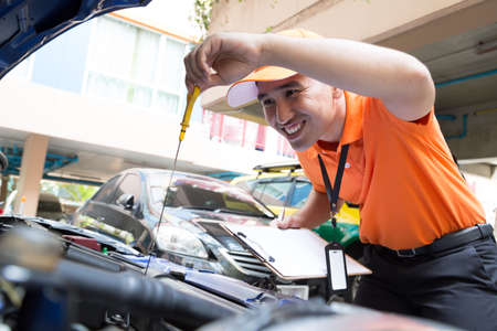Inspector man checking car engine oil