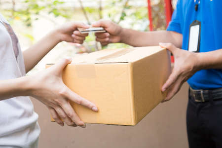 Customer paying by credit card for shipping product and sending to shipping man