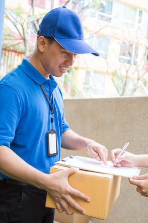 Customer accepting a delivery of cardboard boxes from deliveryman