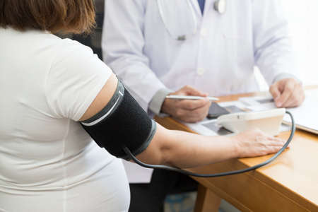 Doctor examining pregnant woman and pressure measurement with a detectorの写真素材