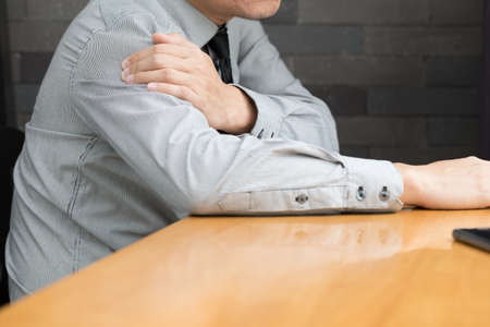 Businessman suffering from pain in the shoulderの写真素材