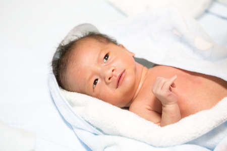 Asian baby wipes with a towel after a bath