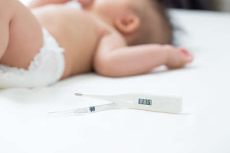 Fever, Baby sick and measuring electric thermometer
