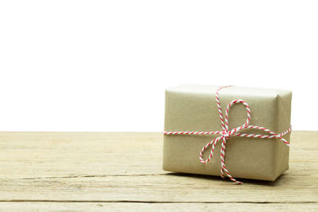 Gift box wrapped in recycled paper on wood backgroundの写真素材
