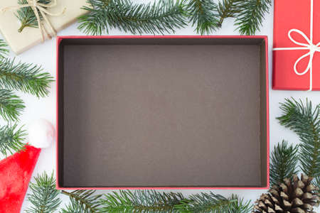 Top view of Christmas composition, gift box, pine cones, fir branches on white background and open...