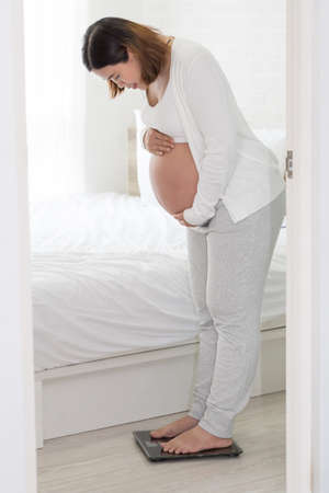 Pregnant women are weighing for weight gain during pregnancy, Eight monthの写真素材