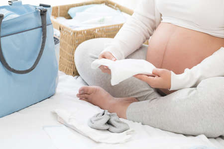 Pregnant women prepare newborn clothes, Bodysuit for babyの写真素材