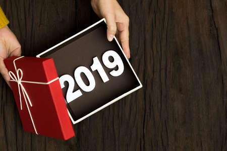 Top view of Happy new year 2019 with red gift box on wooden background