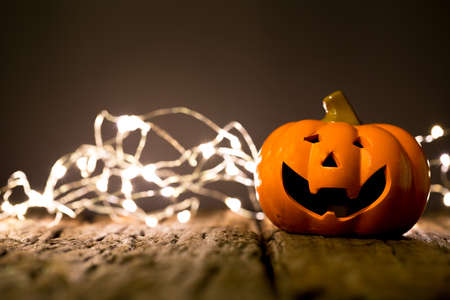 Halloween pumpkin and lighting on wooden backgroundの写真素材