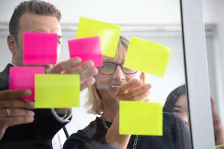 IT worker tracking his tasks on kanban board. Using task control of agile development methodology....