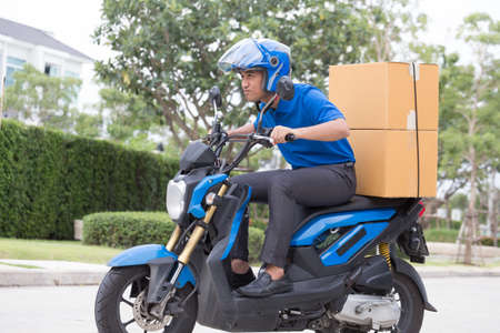 Delivery boy on motorcycle with trunk parcel box driving to fast in rush. Courier delivering order...