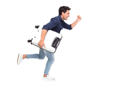 Handsome Caucasian tourist running fast and holding luggage on white background, Vacation travel conceptの写真素材