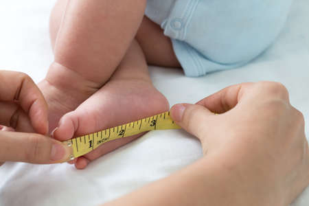 Measuring the size of the foot baby, Infant body development concept, Three month oldの写真素材
