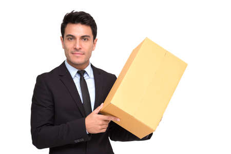 Portrait of a charming businessman dressed in suit holding parcel while standing and looking at camera isolated over white background, Professional of delivery conceptの写真素材