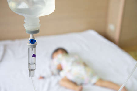 Asian baby boy sleeping on bed with infusion set at child department in the hospital. Children with infectious diseases IPD, Invasive Pneumococcal Disease concept. Infant model one year six monthsの写真素材