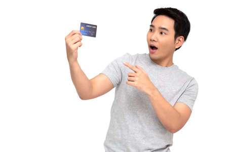 Asian man with wow face and showing credit card on hand isolated on white backgroundの写真素材