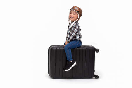 Happy kid Asian boy sitting on a black suitcase isolated over white background, Dreams of travel concept, Two year one month oldの写真素材