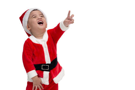 Asian baby boy in a Christmas costume Santa Claus pointing fingers and laughing isolated on white background, Happy and smile conceptの写真素材